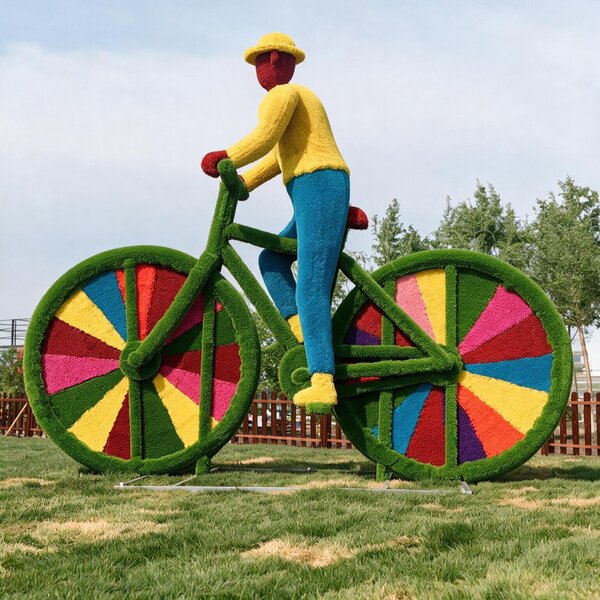Colorful cyclist straw sculpture, large outdoor straw‑art installation